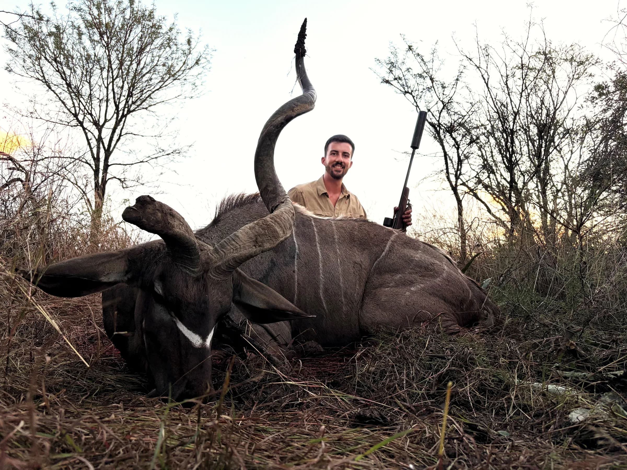 A hunter with a kudu bull in the late afternoon